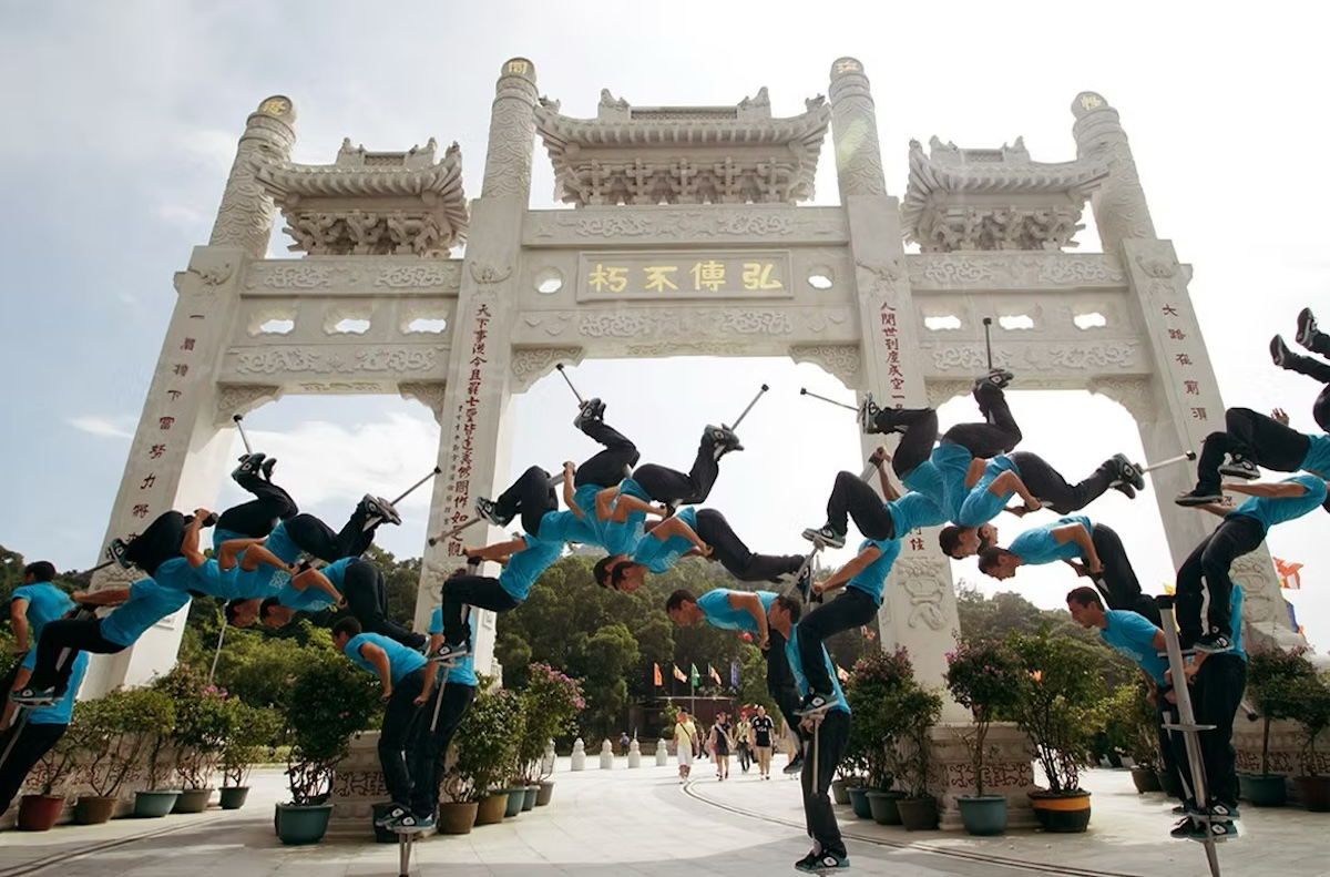 Acrobat on pogo stick flips in front of Japanese gate