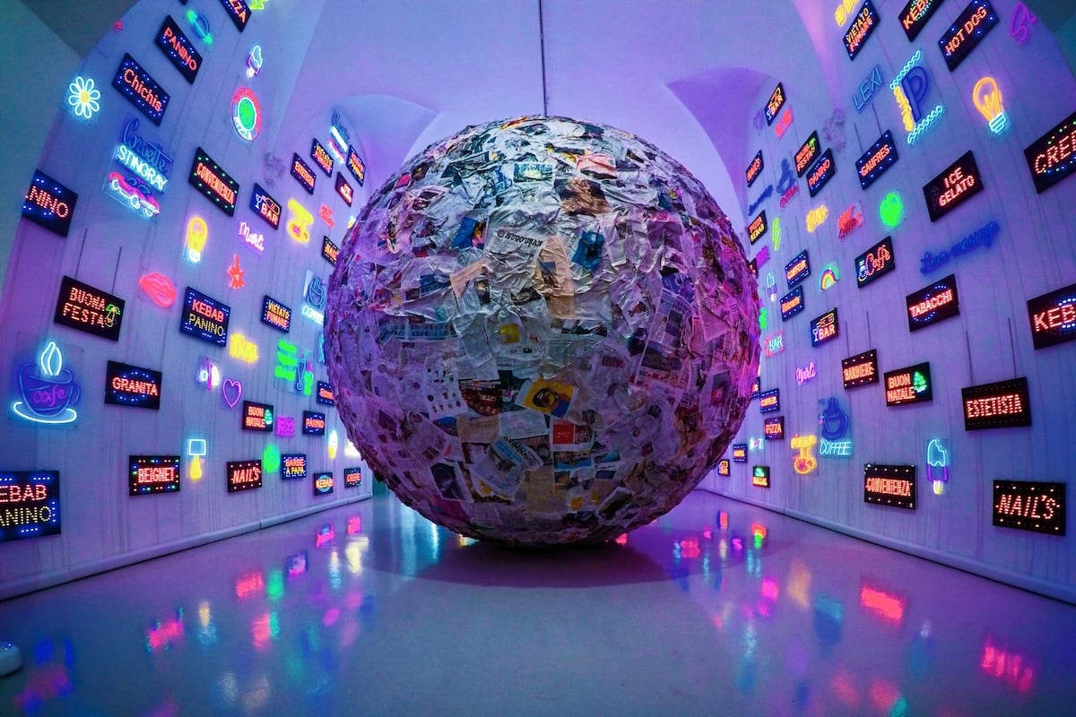Large-ball-made-of-newspapers-surrounded-by-neon-signs